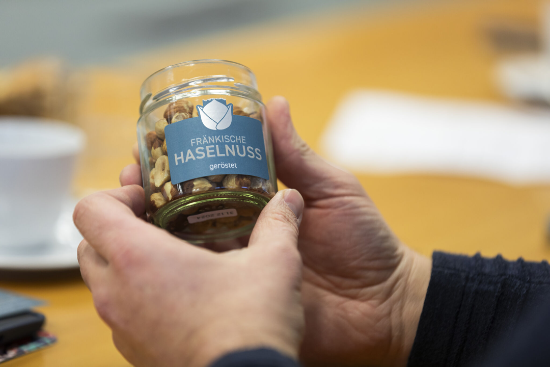 Hand holding a glass of Franconian hazelnuts by Valeria